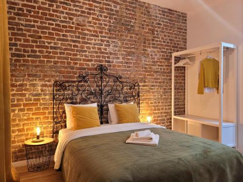 een slaapkamer met een groot bed met een bakstenen muur bij Brand new ROOMS with private bathroom and balcony-terrasse in Brussel