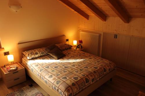 a bedroom with a bed with two lamps on it at Casa dello Sciatore in Bormio