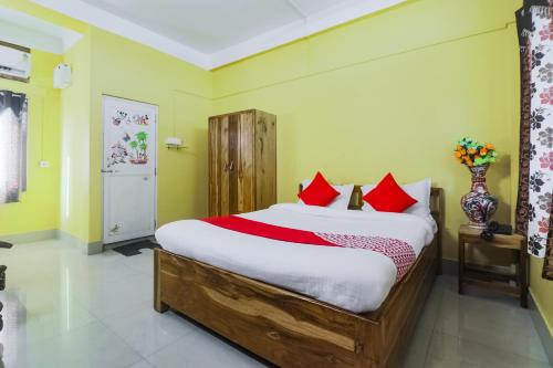 una camera da letto con un grande letto con cuscini rossi di OYO Alohi Ghar a Bhutiāgāon