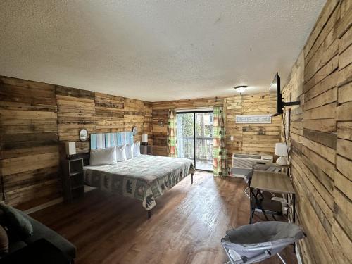 a bedroom with a bed and a wooden wall at Ski Mountain Lodge in Gatlinburg