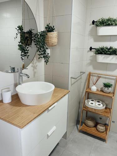 a bathroom with a white sink and a mirror at Monte Azul Penthouse in Ribeira Grande
