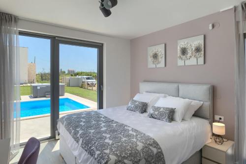 a bedroom with a bed and a view of a pool at Villa Bella and Chiara by SeeAdria Agency in Brtonigla