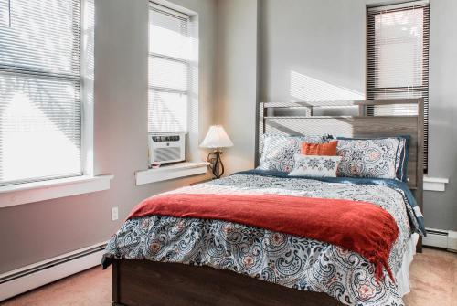 a bedroom with a bed and two windows at Lovely 2BR apartment by Wooster Square- great neighborhood in New Haven