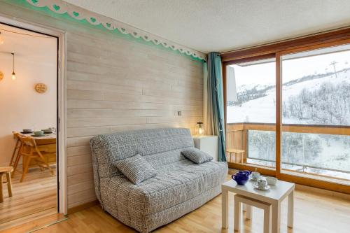 une chambre avec un lit et une grande fenêtre dans l'établissement Le Winter, à Villarembert