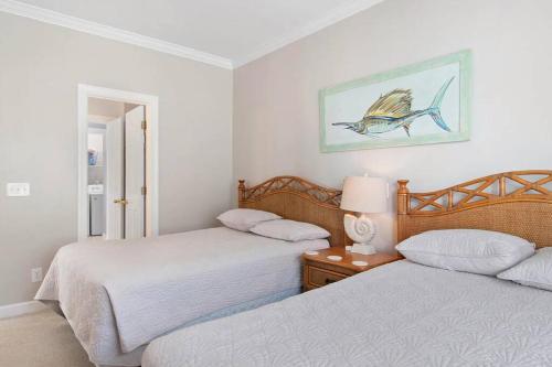 um quarto com 2 camas e uma mesa com um candeeiro em Paradise Villa em Ocean Isle Beach