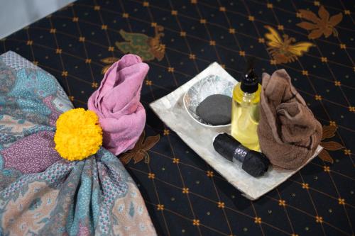 烏布的住宿－普納瑪別墅酒店，一张桌子,上面有一条毛巾和一瓶香水