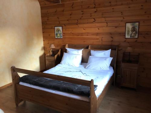 een bed in een kamer met een houten muur bij Inspiration Montagne Chambre d'hôtes in Névache