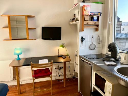uma pequena cozinha com uma secretária e um lavatório em HYPERCENTRE VESLE - Studette 1 em Reims