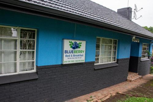 a blue building with a sign on the side of it at BLUEBERRY BED AND BREAKFAST in Pietermaritzburg