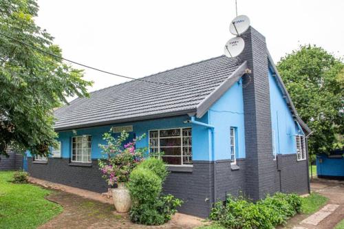 ein blaues und schwarzes Haus mit Sat-TV in der Unterkunft BLUEBERRY BED AND BREAKFAST in Pietermaritzburg