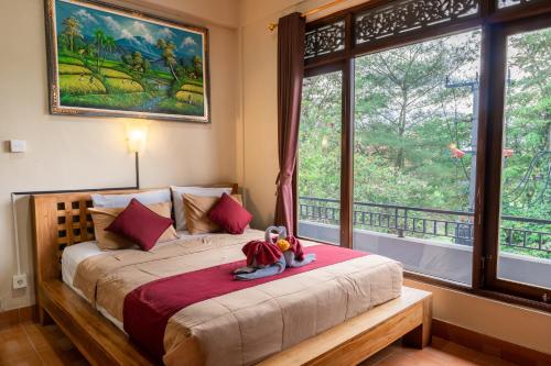 a bedroom with a bed with two stuffed animals on it at Purnama House in Ubud