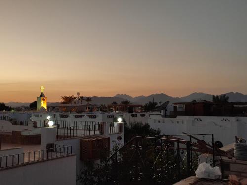 a view of a city at sunset with a clock tower at Farsha View in Sharm El Sheikh