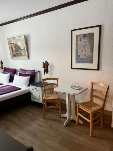 Cette chambre comprend un lit, une table et des chaises. dans l'établissement Restaurant- Hotel- Biergarten Haduloha, à Otterndorf