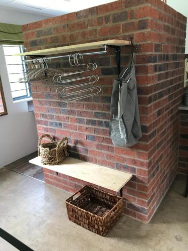a brick wall with a shelf and utensils on it at BAA BAA RESIDENCE in Hillcrest