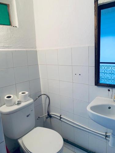 a white bathroom with a toilet and a sink at Riad TaTam House in Marrakech