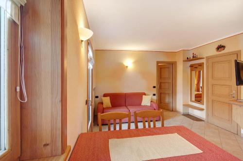 sala de estar con mesa roja y sillas en Baita Pemont en Livigno
