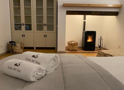 a bedroom with a bed with two pillows and a fireplace at Casa do Vale in Marvão