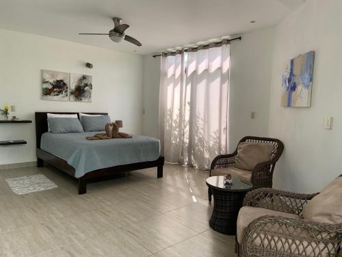 a bedroom with a bed and a couch and a chair at Las Perlitas Rentals Playa Samara in Sámara