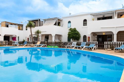 a swimming pool in front of a house at Casa Piquel in Corralejo