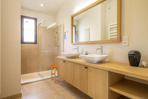 een badkamer met 2 wastafels en een spiegel bij Les Cerisiers du Mont Ventoux in Malaucène