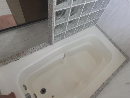 y baño con bañera y estante. en GuestHouse Casa da Montanha, en Río de Janeiro