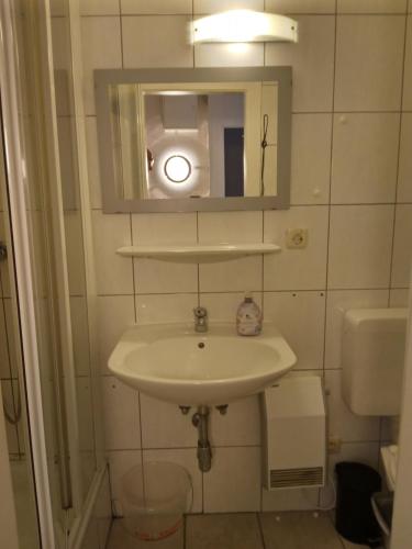 ein Badezimmer mit einem Waschbecken, einem Spiegel und einem WC in der Unterkunft Chalet Rosemarie in Bad Gastein