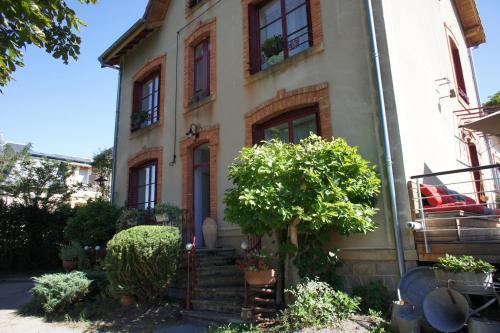 uma casa com uma árvore em frente em MAS TERRE Chambres d'Hôtes em Lezoux