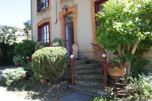 ein Haus mit einer Treppe, die zu einer Tür führt in der Unterkunft MAS TERRE Chambres d'Hôtes in Lezoux