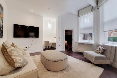 a living room with a couch and a tv at Sir Hans Sloane Apartments in London