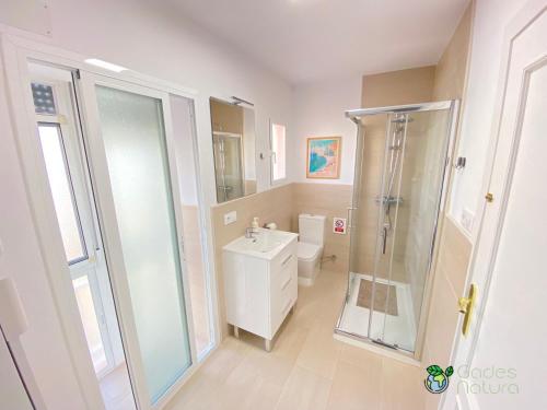 uma casa de banho com um chuveiro, um WC e um lavatório. em Gades Natura Apartment a 450 mts Victoria beach em Cádiz