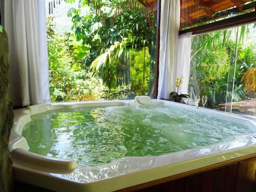 a bath tub in a room with a window at Pousada Riacho Dos Cambucas in Abraão