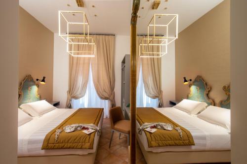 a hotel room with two beds and a mirror at Hotel Mozart in Rome
