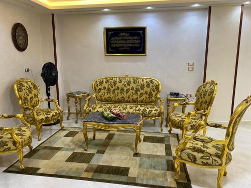 a living room with gold furniture and a couch at شقة فندقية مميزة بالمنصورة in Ṭalkha