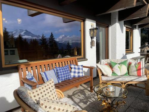 porche con banco, 2 sillas y mesa en Buena Vista Mountain Lodge, en Mittersill