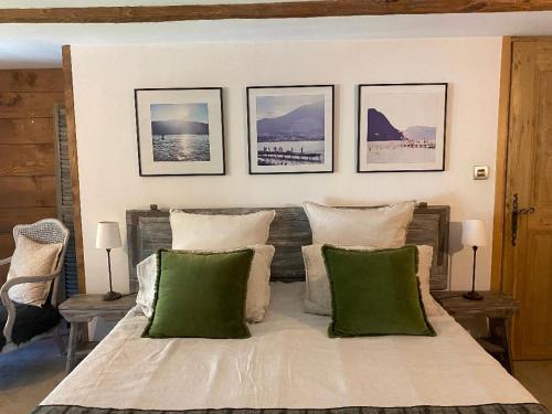 a bedroom with a large bed with green pillows at La Perle de la Lauzière, chambres d hôtes in Argentine