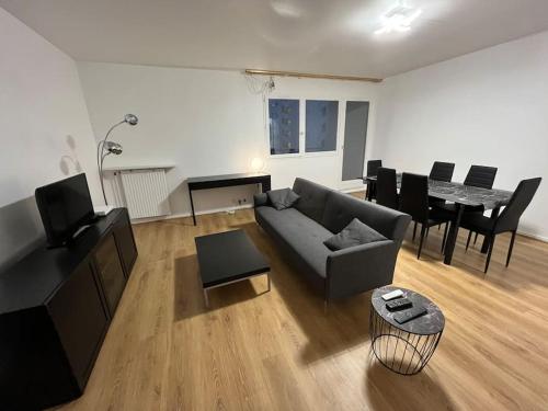uma sala de estar com um sofá e uma mesa em 4 pièces avec parking à 2 min du centre commercial et du lac de Créteil em Créteil