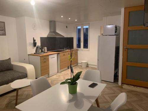 een keuken en een woonkamer met een tafel en stoelen bij 1)Maison chaleureuse à 2 pas de la Seine in Duclair