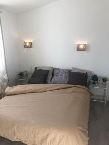 - une chambre avec un lit et deux lumières sur le mur dans l'établissement Les Micocouliers - Spacieuse maison,4chambres ,avec Jardin- Parking -Wifi, à Béziers