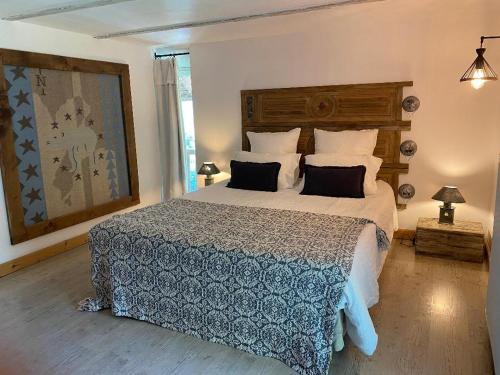 a bedroom with a large bed with a blue comforter at La Perle de la Lauzière, chambres d hôtes in Argentine