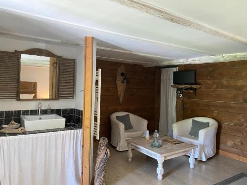 - un salon avec un lavabo et une table dans l'établissement La Perle de la Lauzière, chambres d hôtes, à Argentine