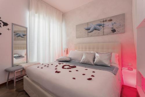 a bedroom with a white bed with roses on it at Cagliari Centro Città Rooms in Cagliari