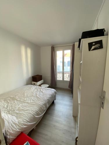 a bedroom with a white bed and a window at Appartement F2 - Paris 18 in Paris