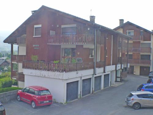czerwony samochód zaparkowany przed budynkiem w obiekcie T2 cosy, proche centre Samoëns, animaux admis, parking - FR-1-629-67 w mieście Samoëns