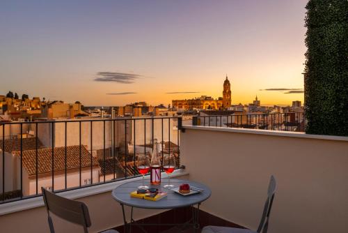 a table with two glasses of wine on a balcony at Coeo Apart-Hotel Peña in Málaga