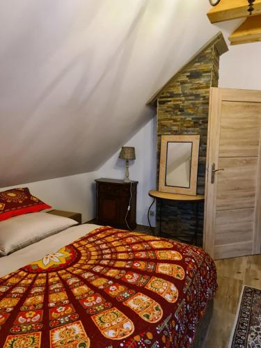 a bedroom with a large bed and a fireplace at Chata w Grapie in Koniaków