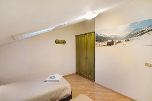 une chambre avec un lit et une porte avec un tableau dans l'établissement Casa Marcos n 36, à Livigno