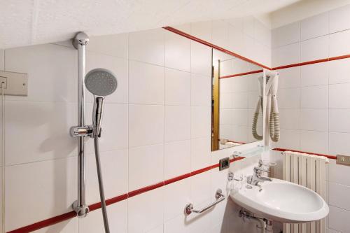 La salle de bains blanche est pourvue d'un lavabo et d'un miroir. dans l'établissement Casa Marcos n 36, à Livigno
