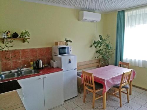 a small kitchen with a table and a microwave at Jucus Vendégház in Zebegény