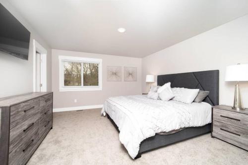 a white bedroom with a large bed and a window at Delightful, new townhome downtown in Billings