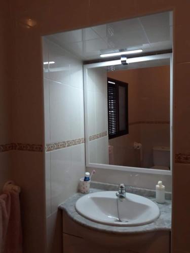 uma casa de banho com um lavatório e um espelho grande em Casa Rural La Maestra em Atajate